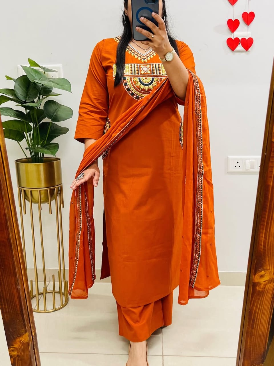 Rust-colored cotton kurta, pant, and dupatta set with embroidery work