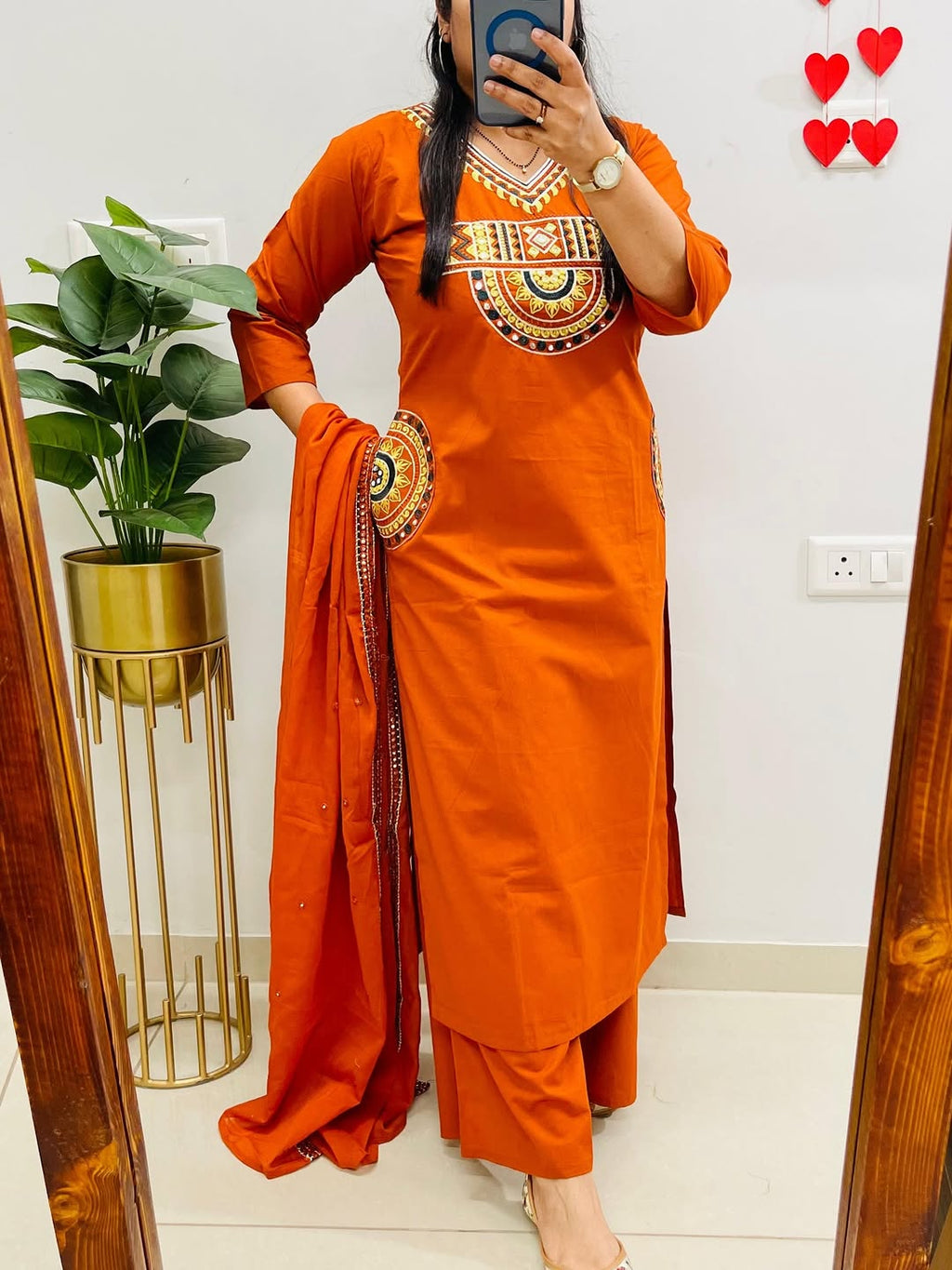 Rust-colored cotton kurta, pant, and dupatta set with embroidery work