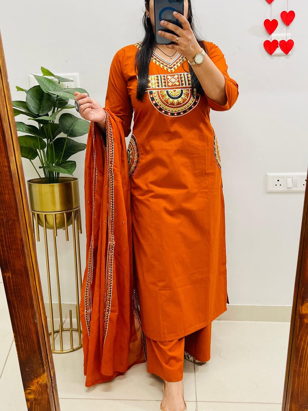 Rust-colored cotton kurta, pant, and dupatta set with embroidery work